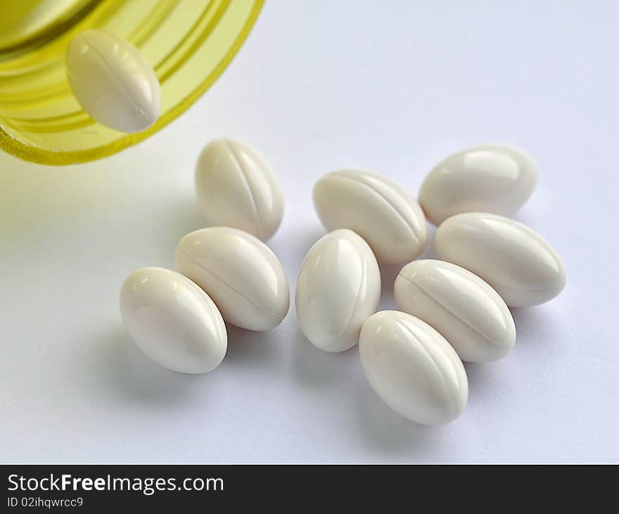 Close up of yellow bottle and white capsules. Close up of yellow bottle and white capsules