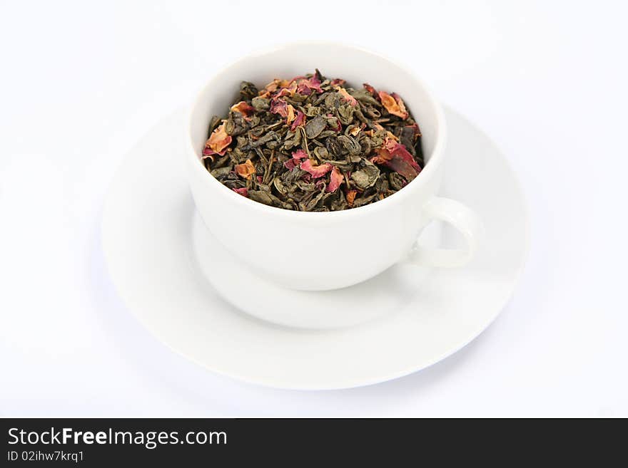 Cup filled with dried green tea leaves and rose petals. Cup filled with dried green tea leaves and rose petals