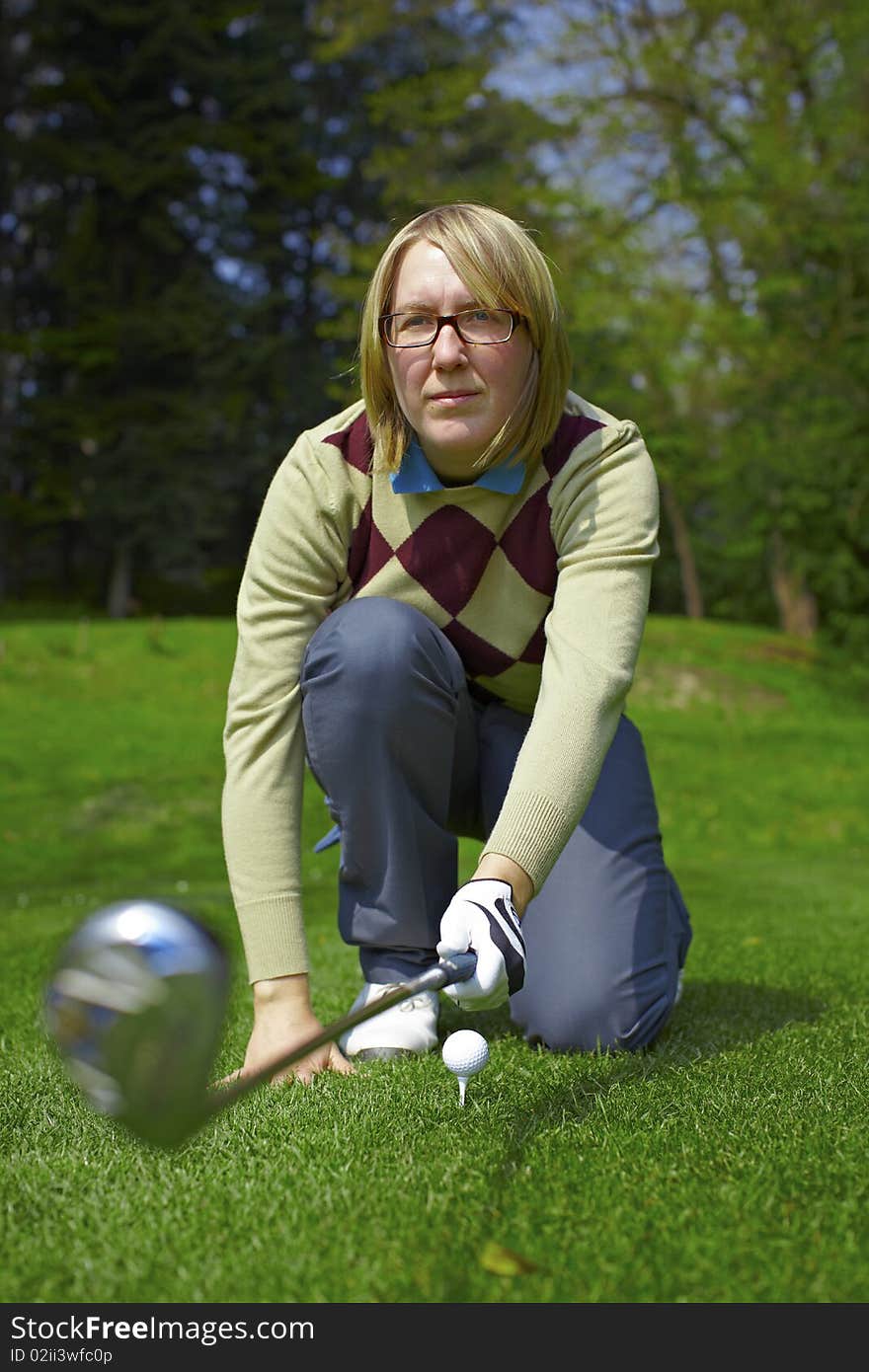 Woman golfer aiming with iron