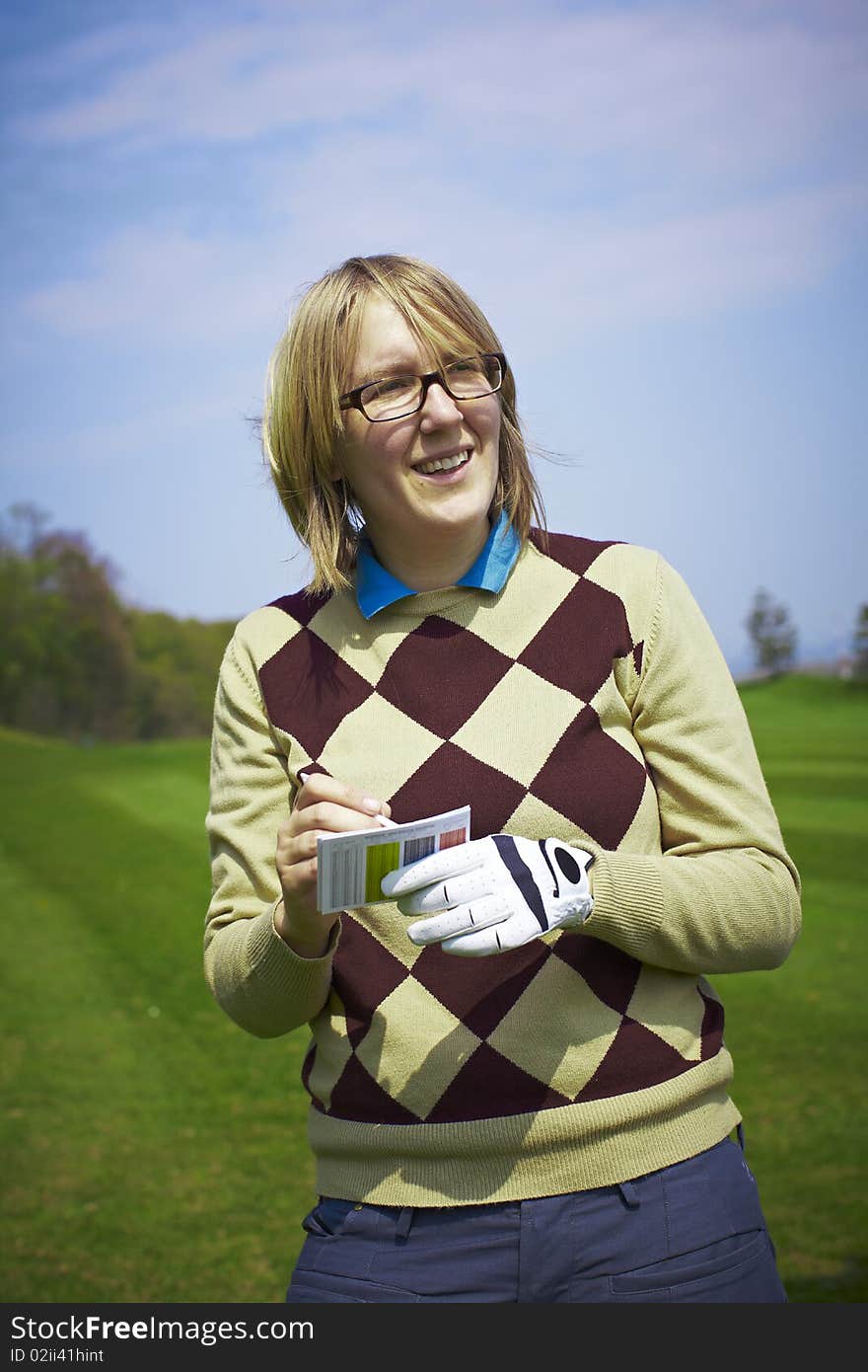 Golfer woman writing handicap and smiling.