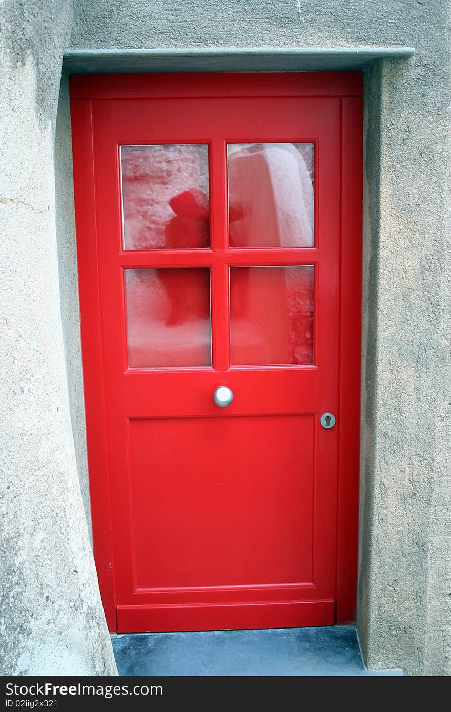 Detail of a red door in a restorated stone house in one italian country village