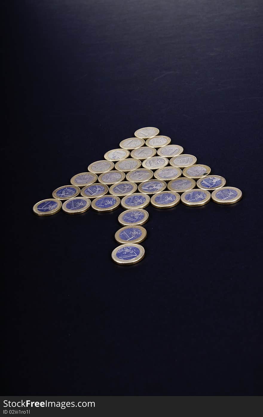 This image depicts a group of coins, arrow-shaped, indicating a direction. This image depicts a group of coins, arrow-shaped, indicating a direction