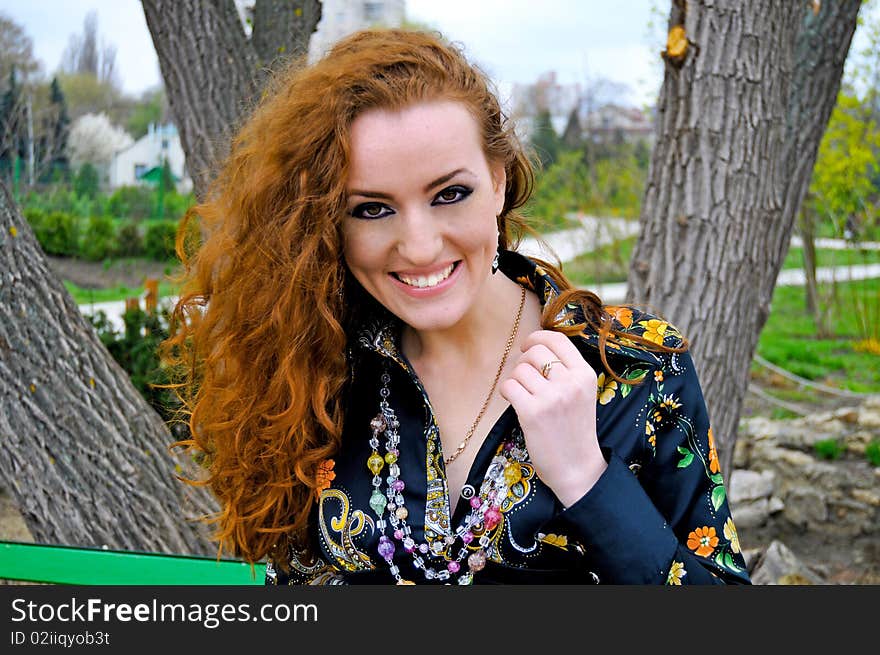 Red head girl smiling in the park,emotional