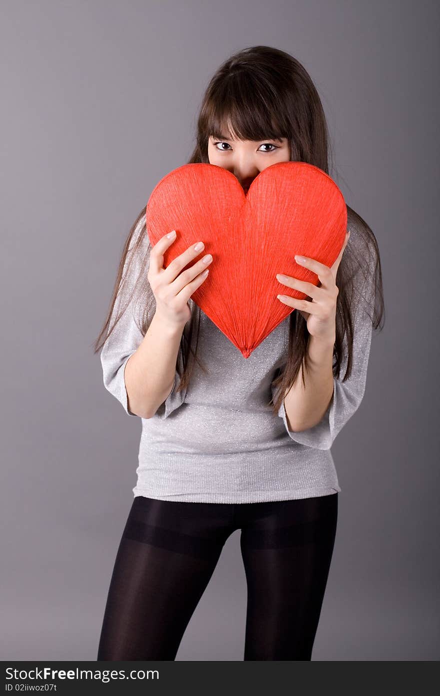 Beautiful woman holding red heart studio shot