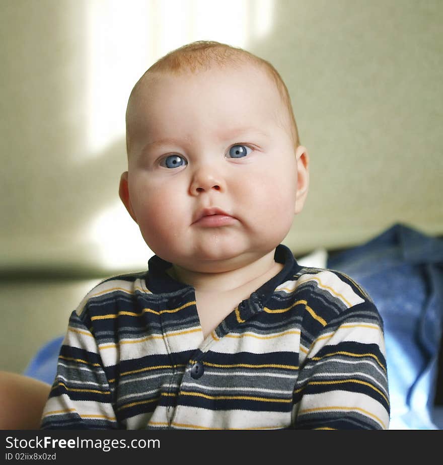 Portrait of beautiful little boy, looking with curiosity large blue eyes on the world