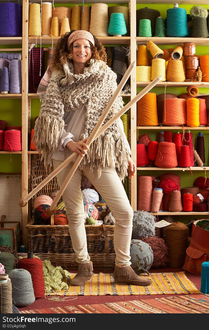 Woman Wearing Knitted Scarf Holding giant needles