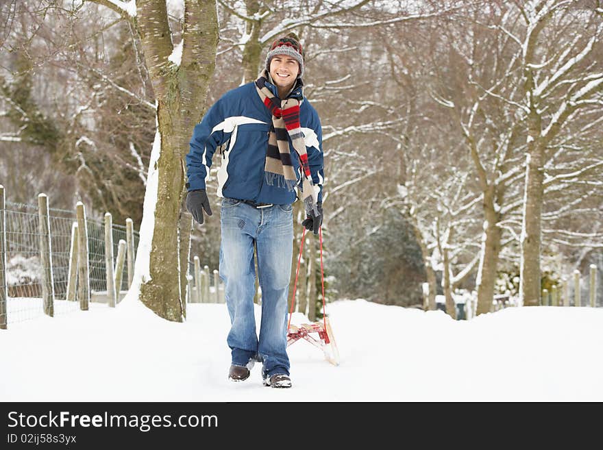 Man Pulling Sledge Through Winter Landscape