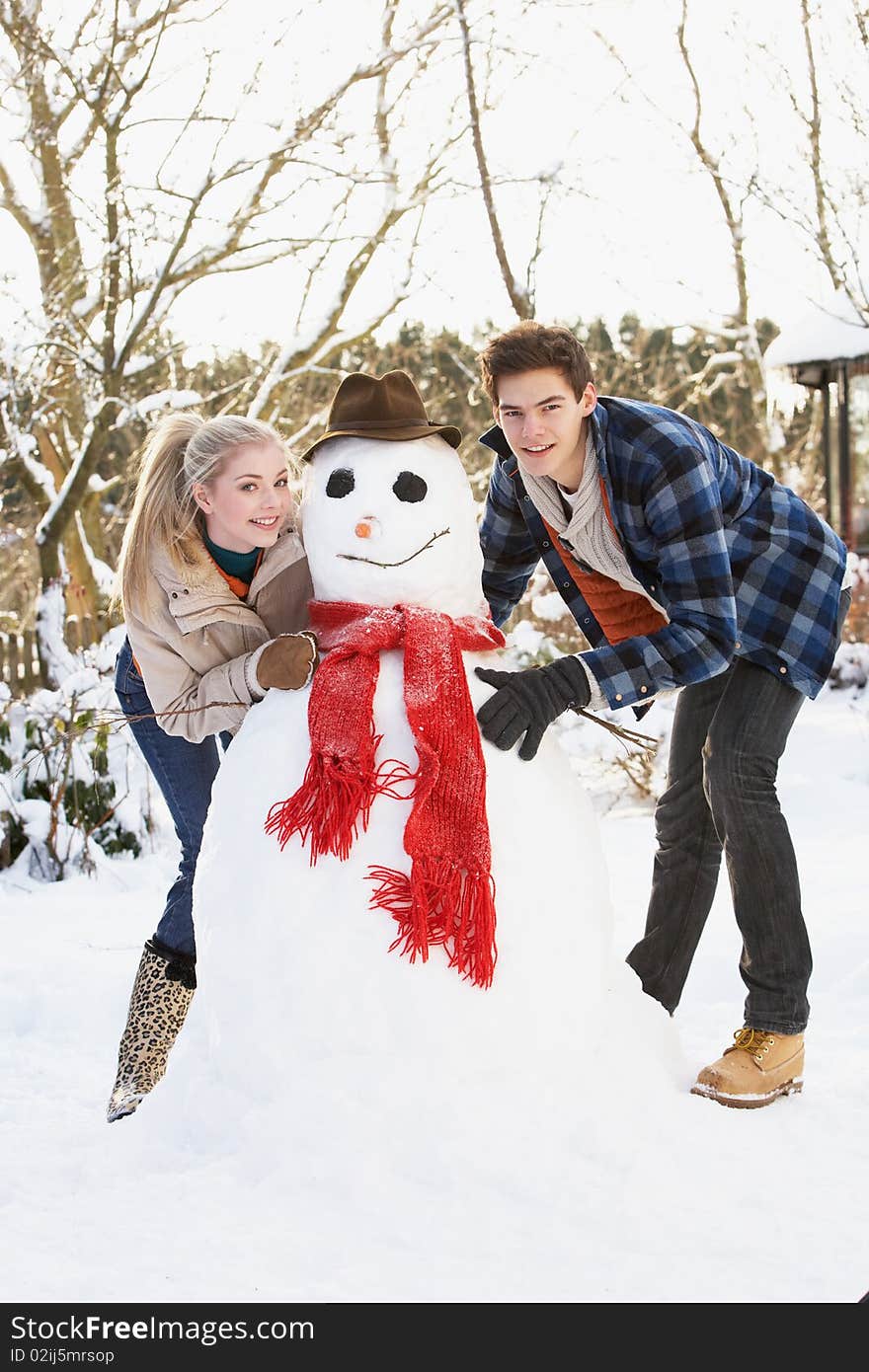 Teenage Couple Building Snowman