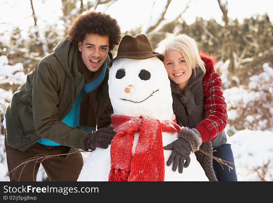 Teenage Couple Building Snowman