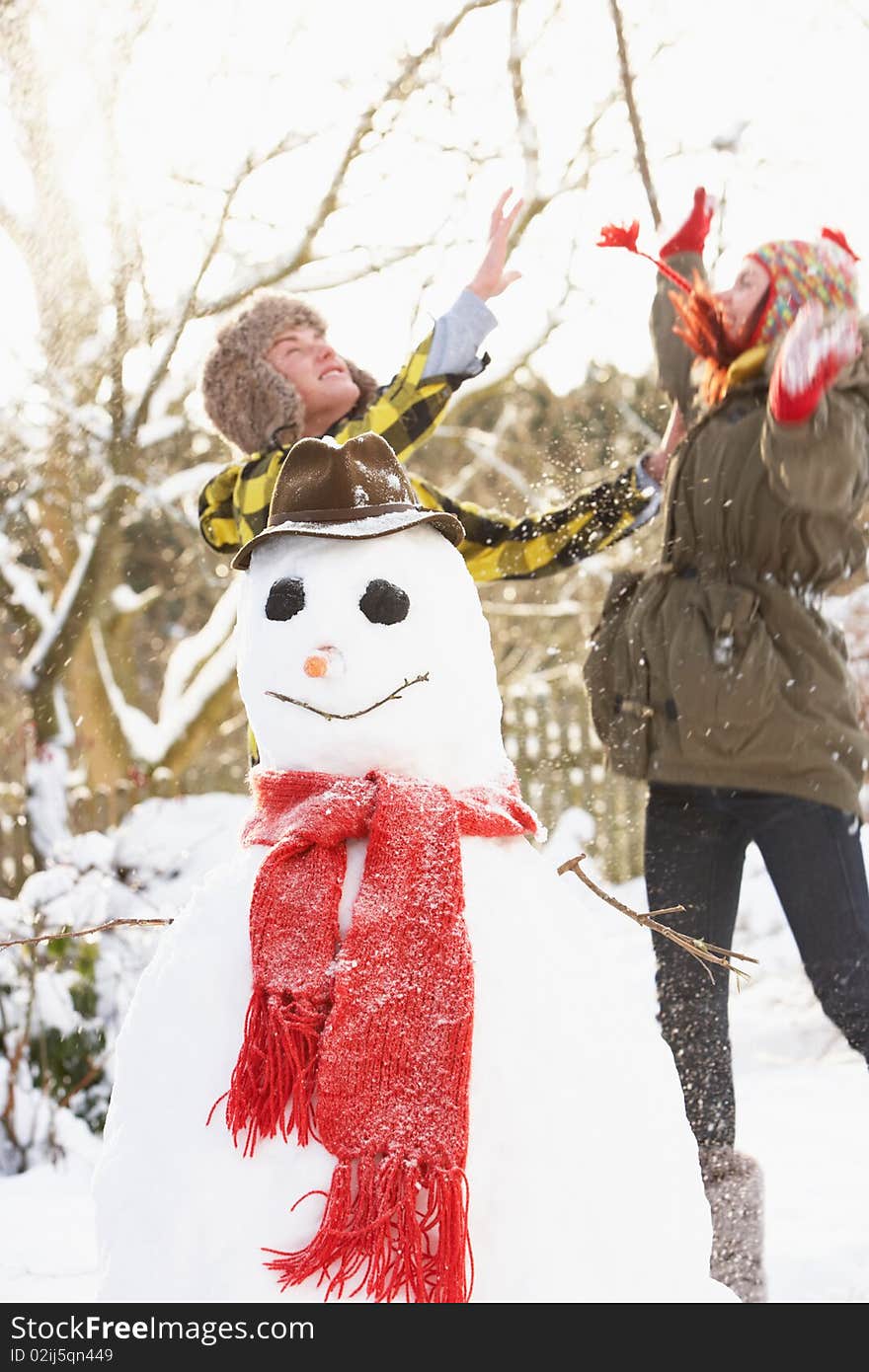 Teenage Couple Building Snowman