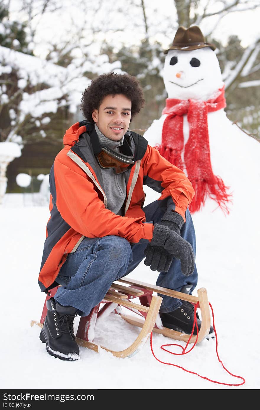 Man With Sledge Next To Snowman