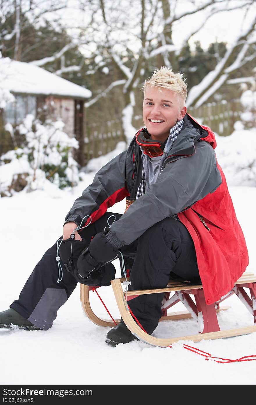 Teenage Boy With Sledge Smiling At Camera