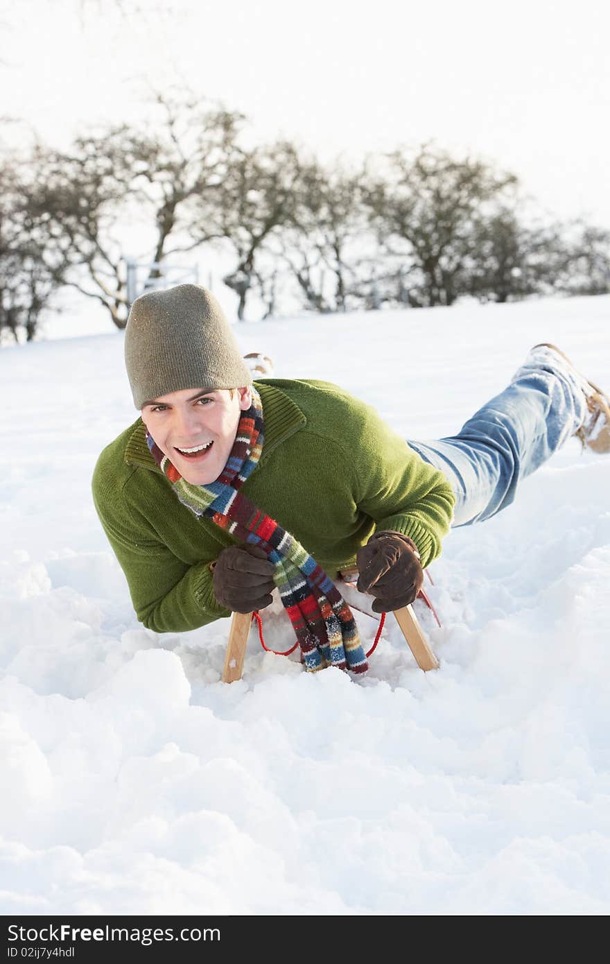 Man Riding On Sledge In Snowy Landscape