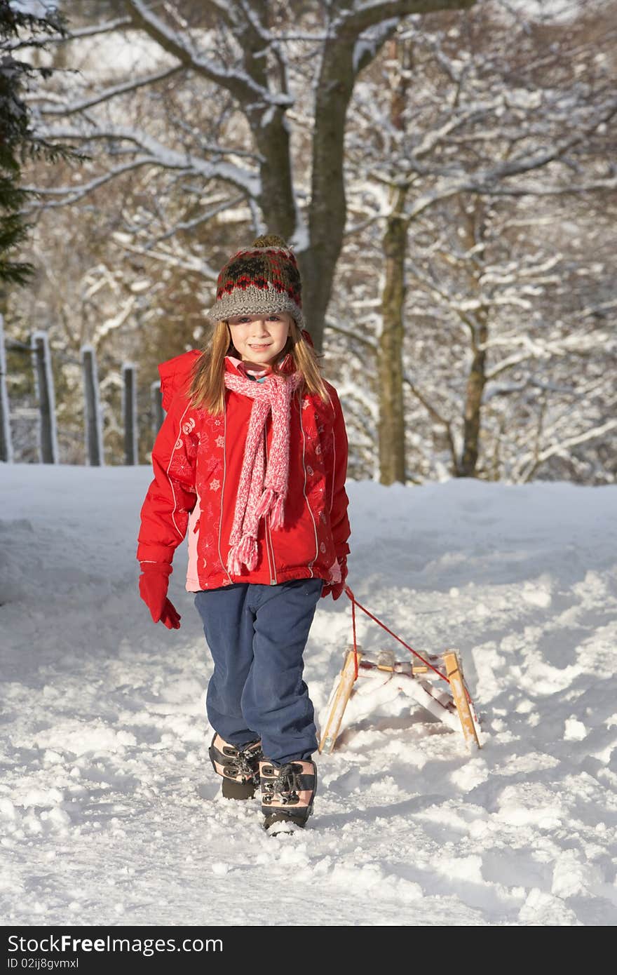 Young Girl Pulling Sledge Through Snowy Landscape