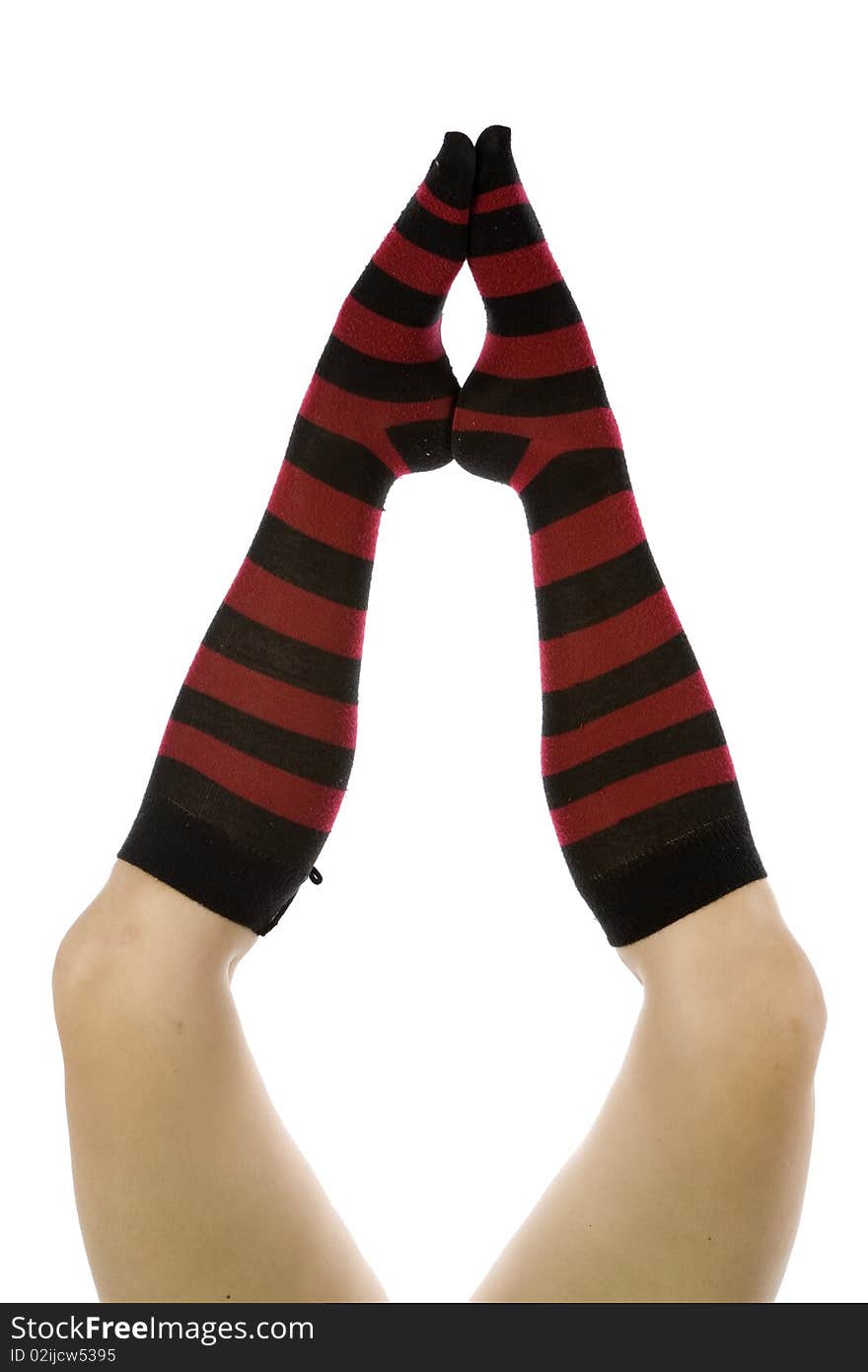 A pair of womans legs with red and black striped socks. A pair of womans legs with red and black striped socks.