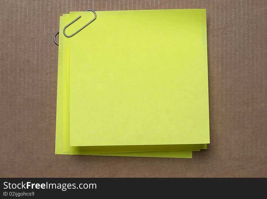 Colored sticker note with metal clip on cardboard