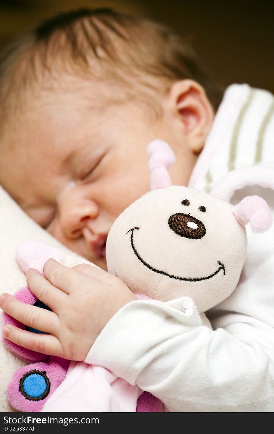 Close-up of a stuffed animal and a sleeping baby. Close-up of a stuffed animal and a sleeping baby