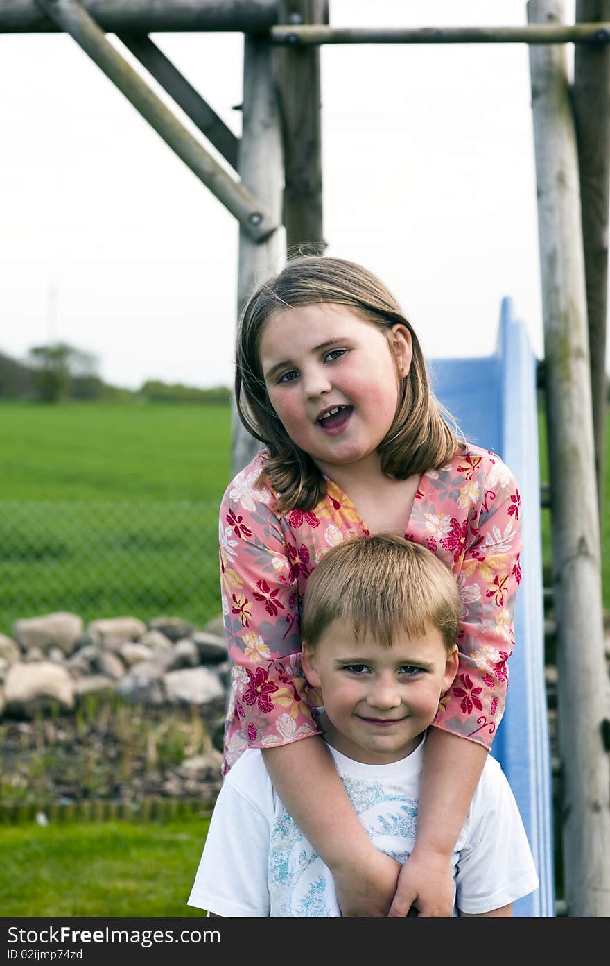 Portrait of two young sibs on a slide. Portrait of two young sibs on a slide