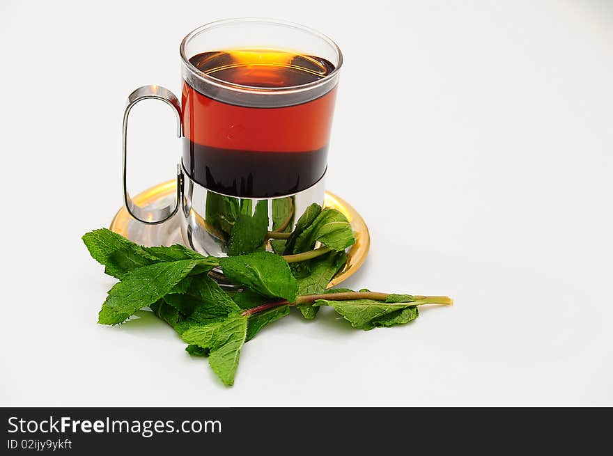 A glass of hot tea on a saucer. A glass of hot tea on a saucer.