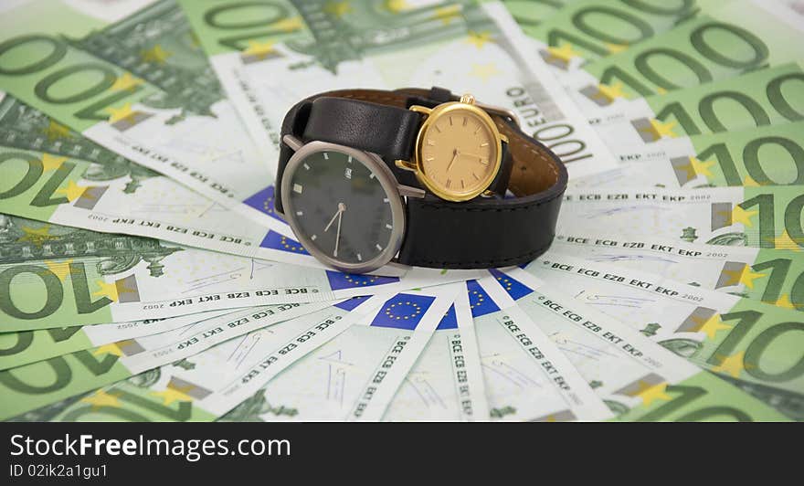 Time is money concept photo: two watches on one hundred euro banknotes background