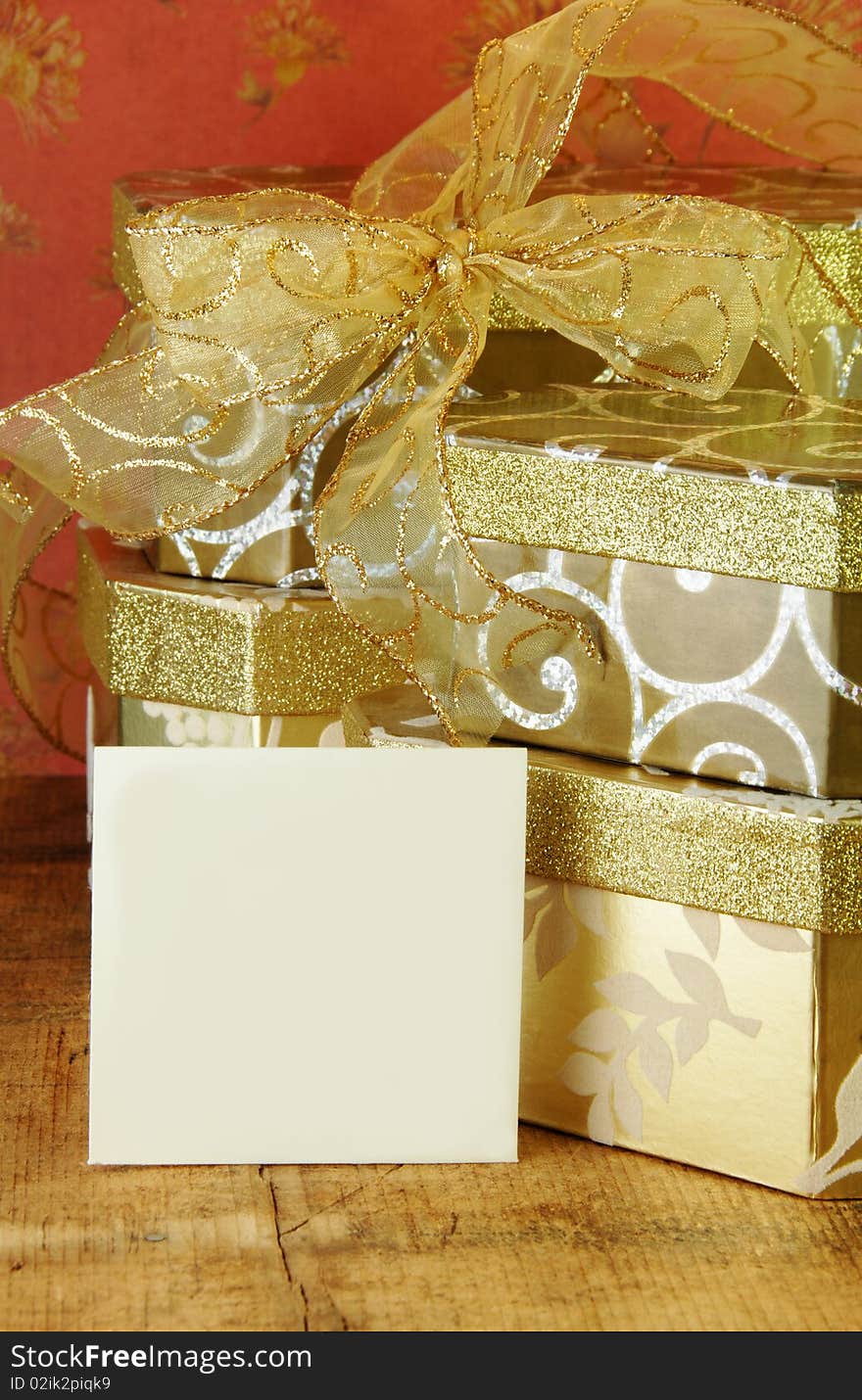 Gift boxes stacked with gold ribbon and gift card blank for your text. Gift boxes stacked with gold ribbon and gift card blank for your text.