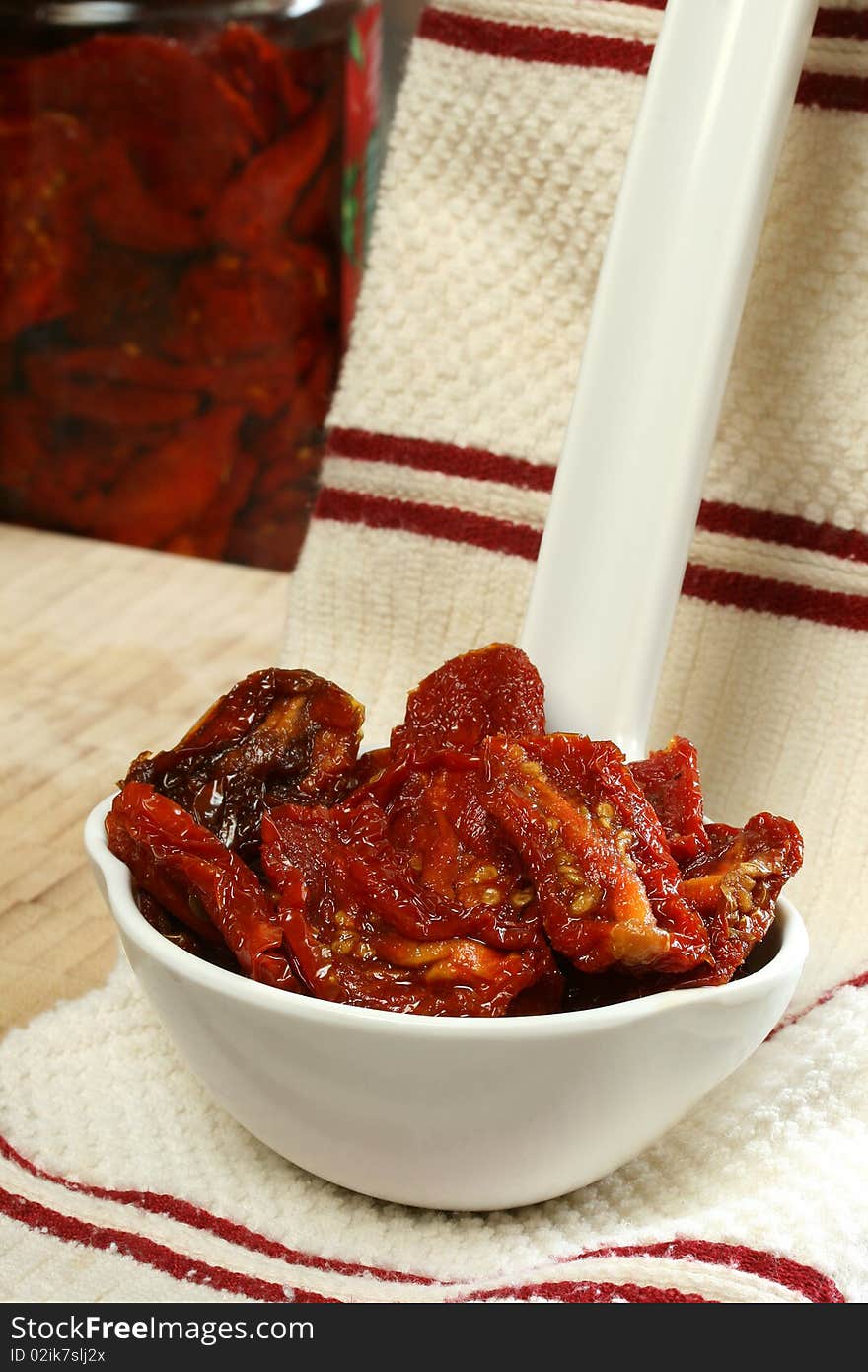 Sun Dried Tomatoes in Olive Oil sitting in large white kitchen spoon