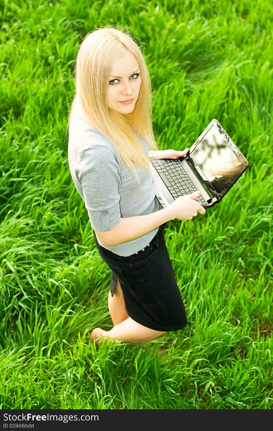 Series. The beautiful business woman with the laptop has a rest in the field