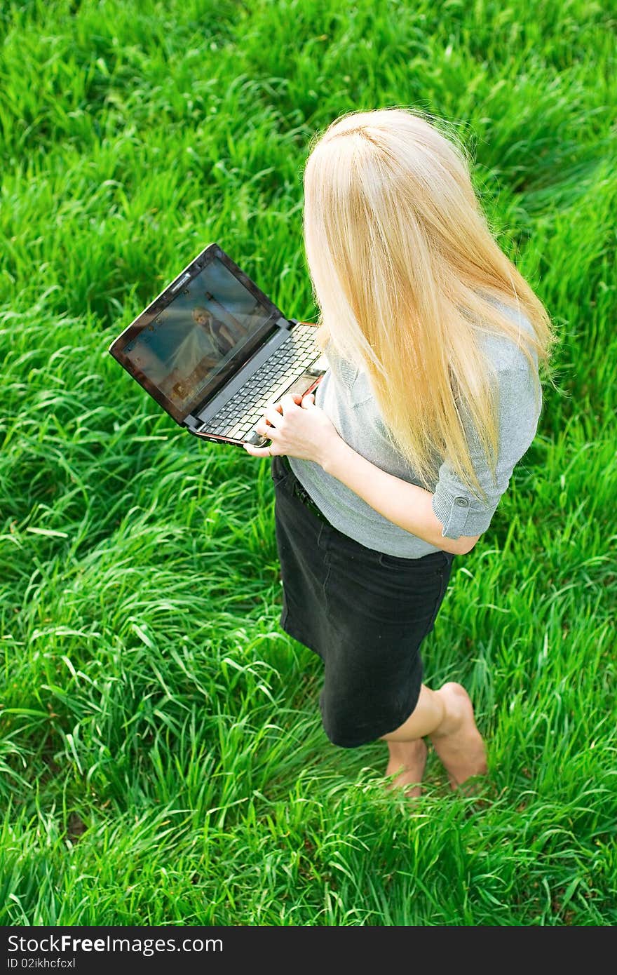 Series. The beautiful business woman with the laptop has a rest in the field