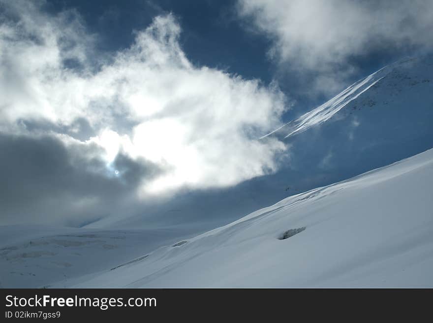 Sun shining through the cloud covering snowy slope. Sun shining through the cloud covering snowy slope.