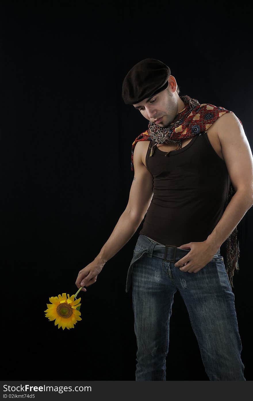 Portrait of young man holding sunflower, isolated over black