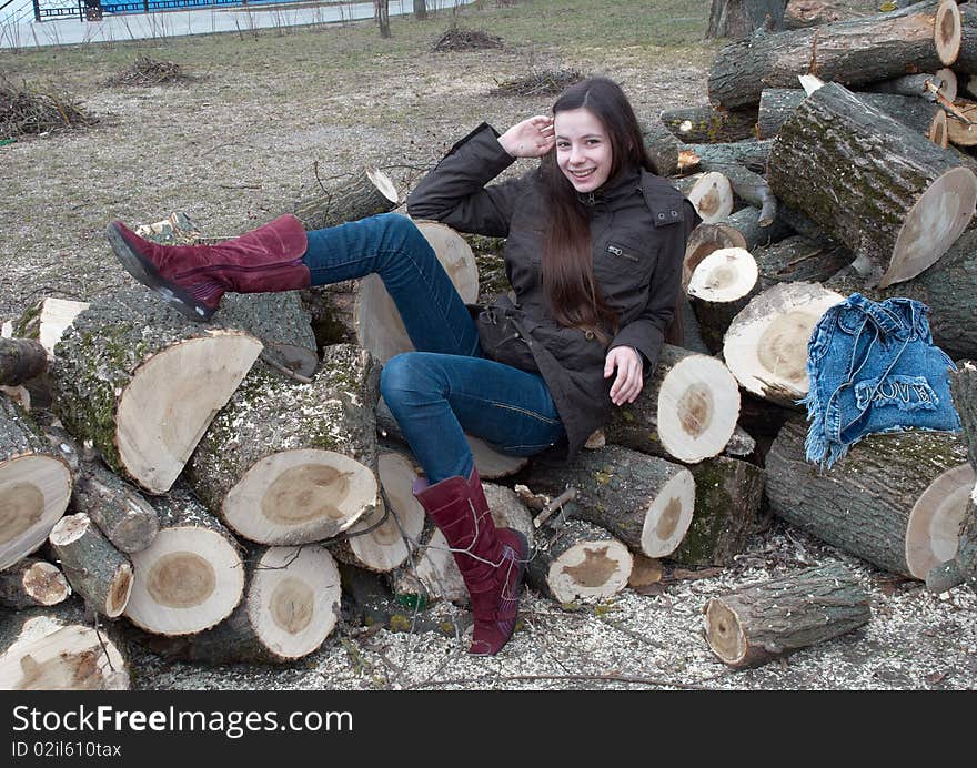 Young beautiful girl lying on logs