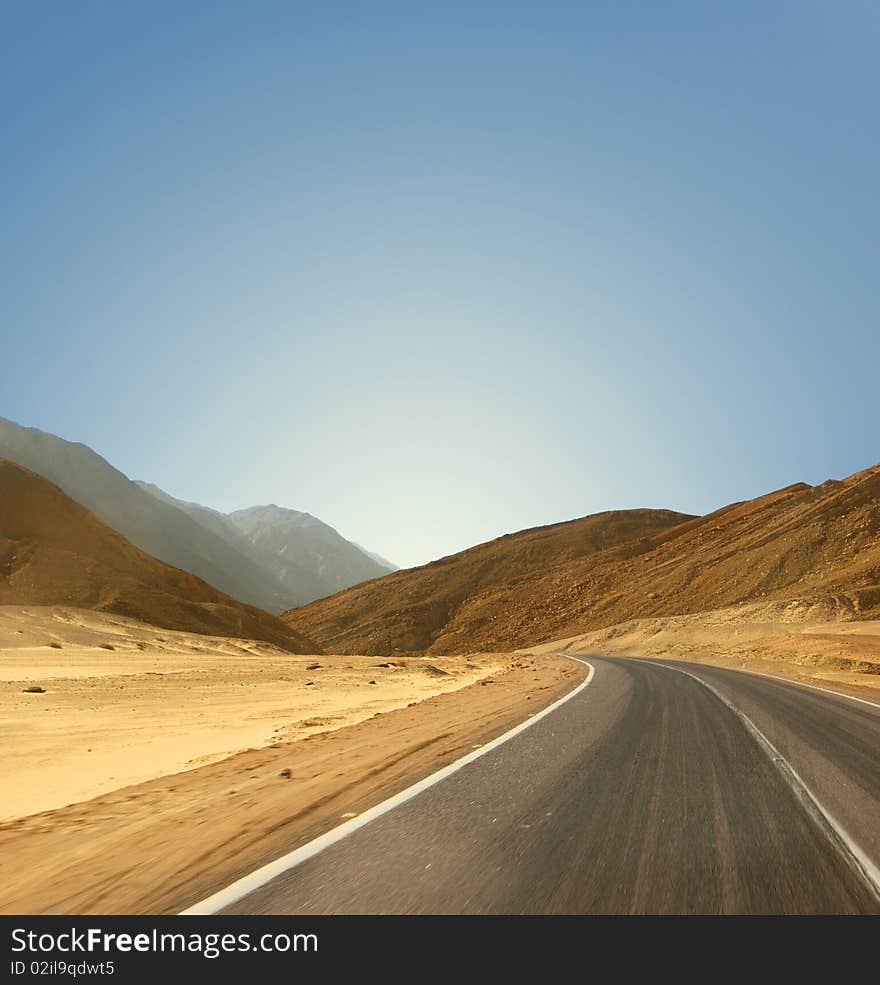 Image of a road in an Egyptian desert on a sky background. Panoramic view. Image of a road in an Egyptian desert on a sky background. Panoramic view.