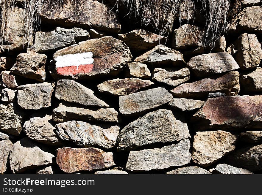 Stonewall with the sign of the mountain path, good for conceptual. Stonewall with the sign of the mountain path, good for conceptual