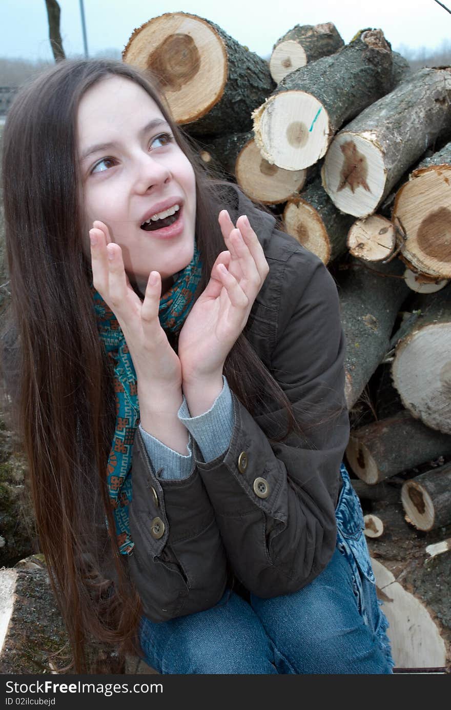 Close-up of young teenage girl sitting on logs. Close-up of young teenage girl sitting on logs