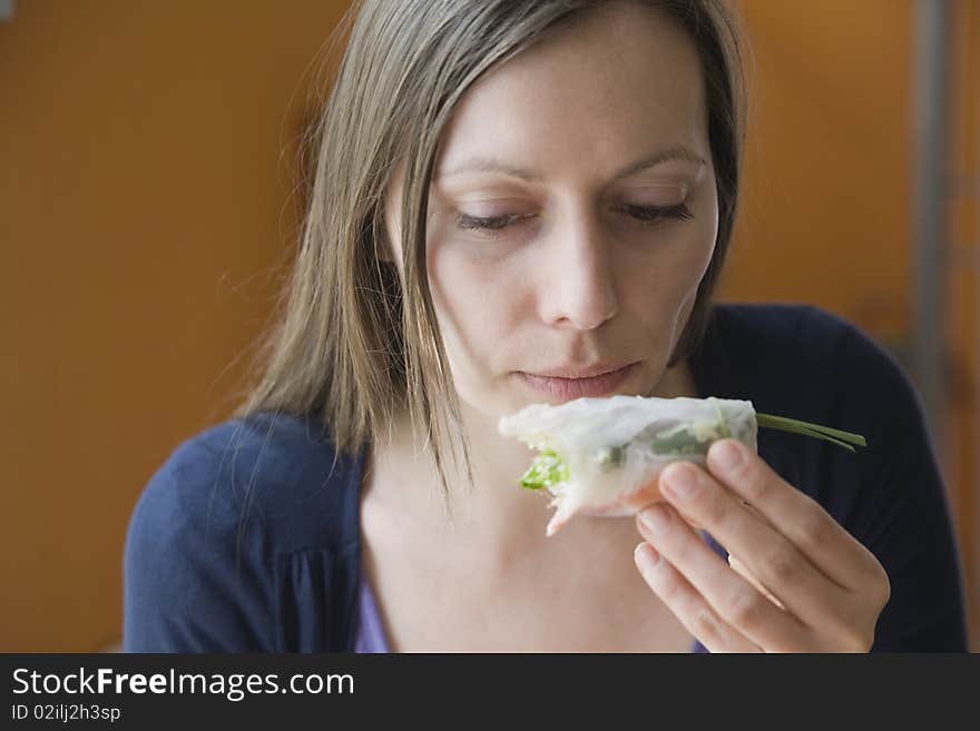 Woman eating a spring roll. Woman eating a spring roll