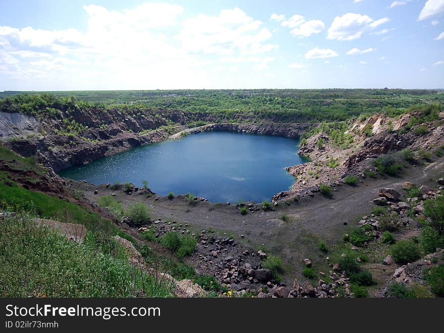 Landscape with blue deep lake in large granite open pit. Landscape with blue deep lake in large granite open pit