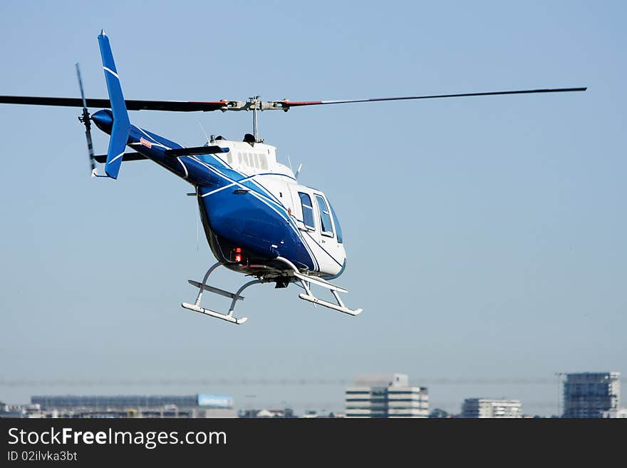 Blue & White Helicopter In Flight.