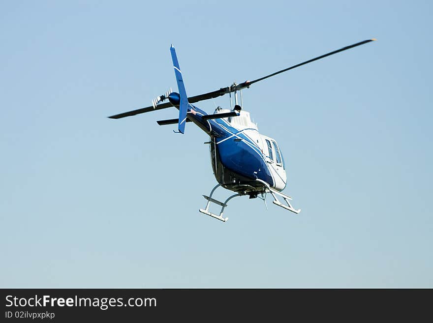 Blue & White Helicopter In Flight.