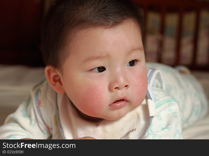 Lovely Chinese baby is playing in the bed