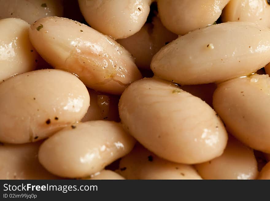 Photo of spanish beans on a white plate with a basil leaf