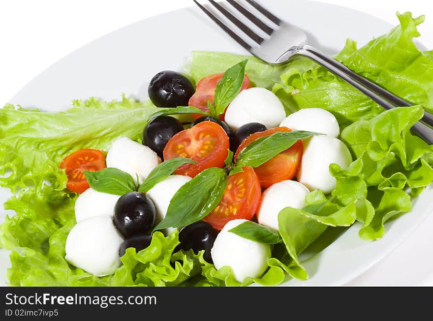 Salad with mozzarella, olives, basil and tomatoes