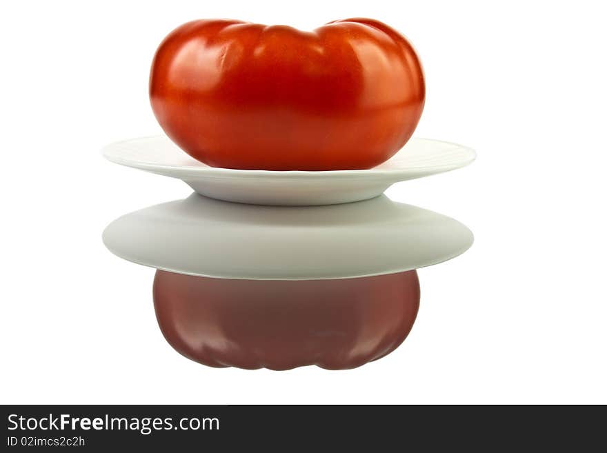 Large red ripe juicy tomato on a plate