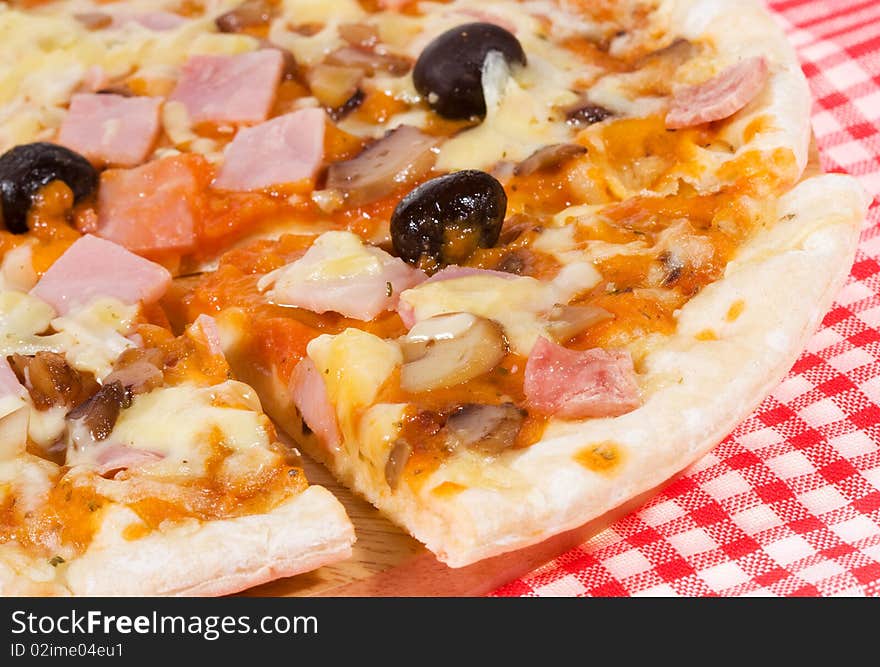 Pizza with ham and vegetables as background