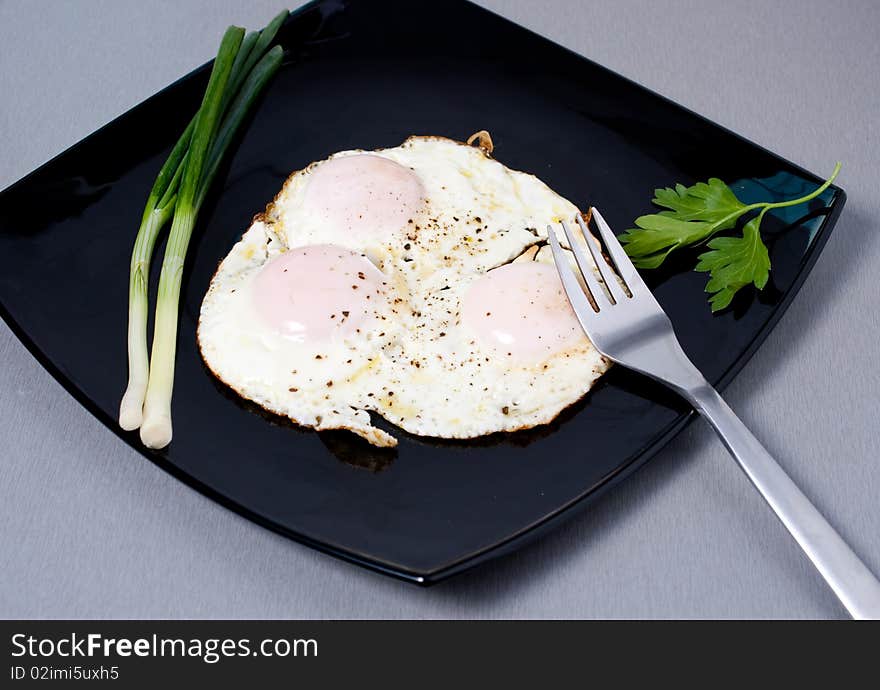 Fried eggs seasoned with salt and pepper