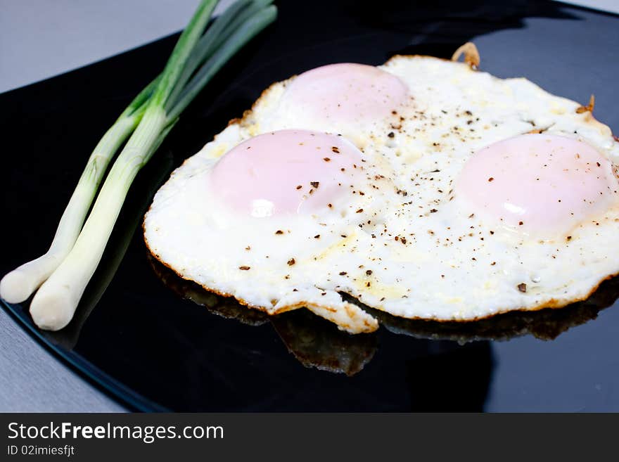 Fried eggs seasoned with salt and pepper