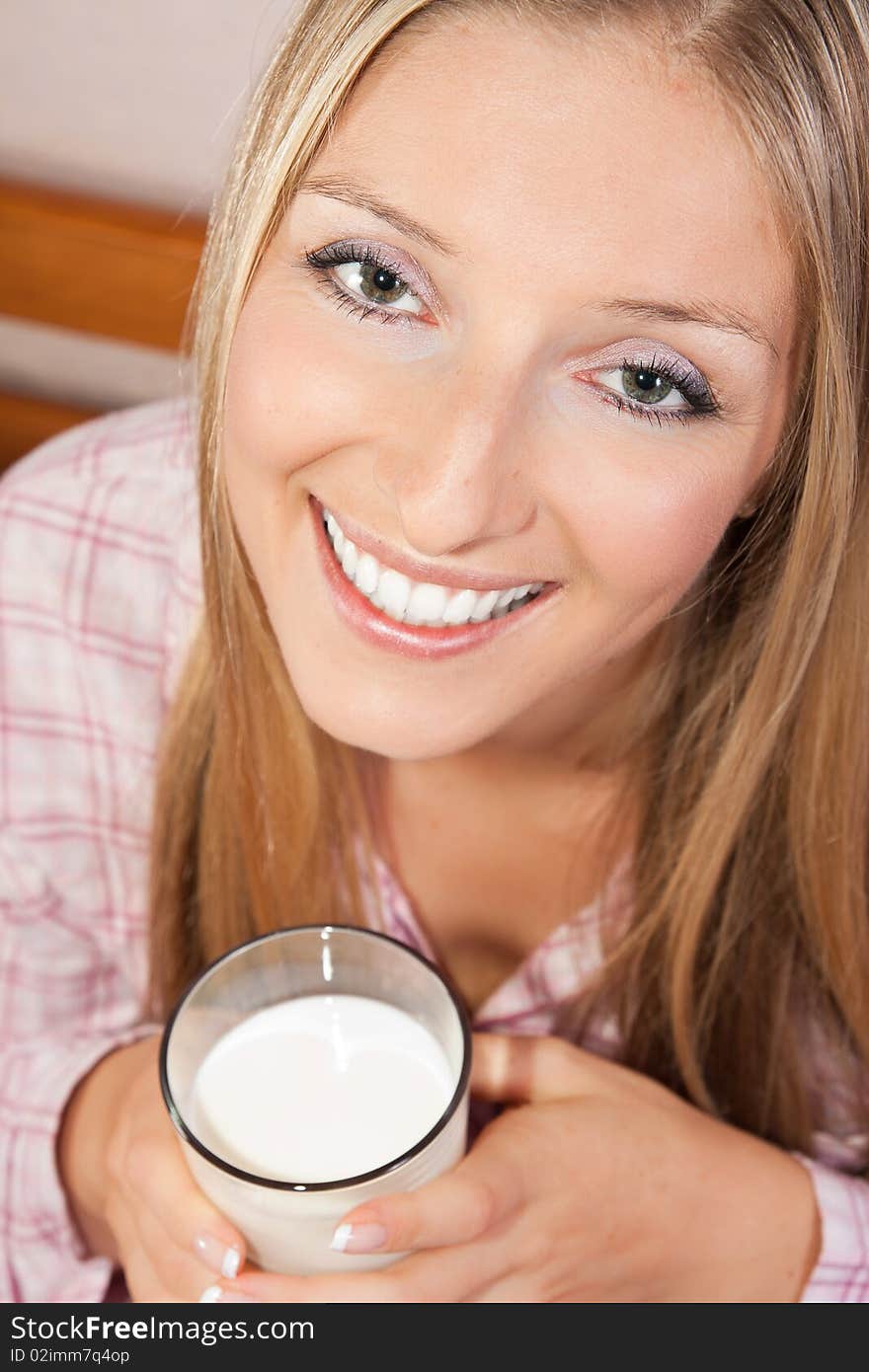 Woman in bed with glass of milk