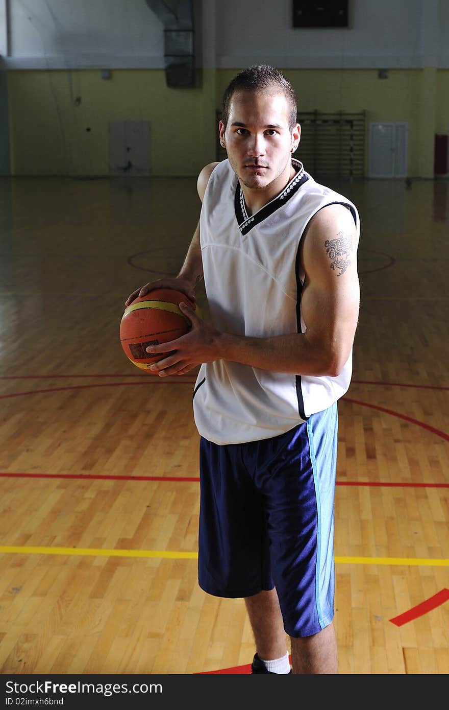 One healthy young man play basketball game in school gym indoor relax. One healthy young man play basketball game in school gym indoor relax