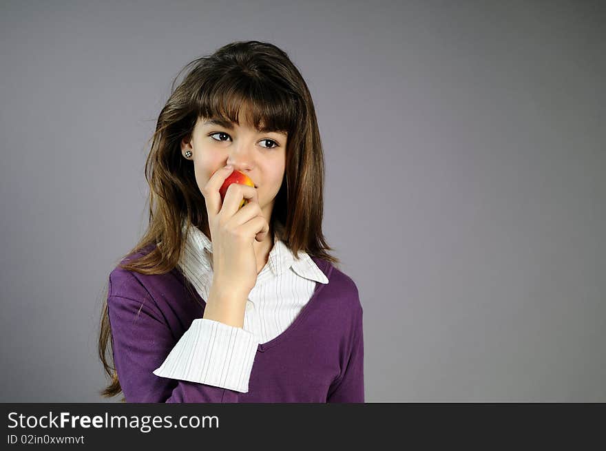 Beautiful teen trying to eat one apple. Beautiful teen trying to eat one apple