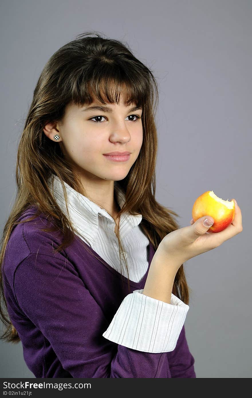 Beautiful school girl eating healthy fruit