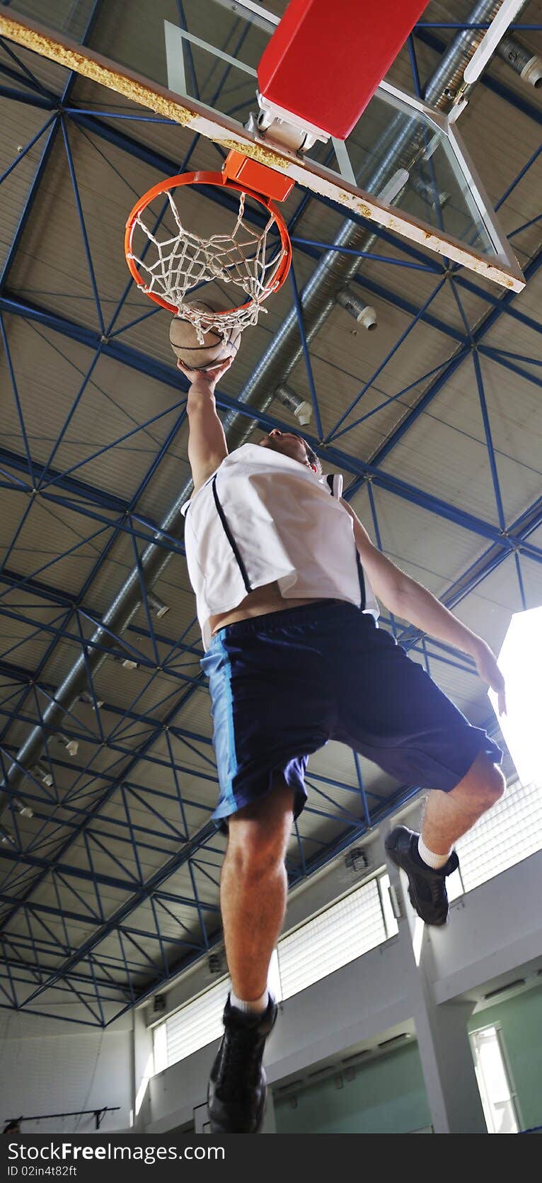 Young healthy man play basketball game indoor in gym. Young healthy man play basketball game indoor in gym